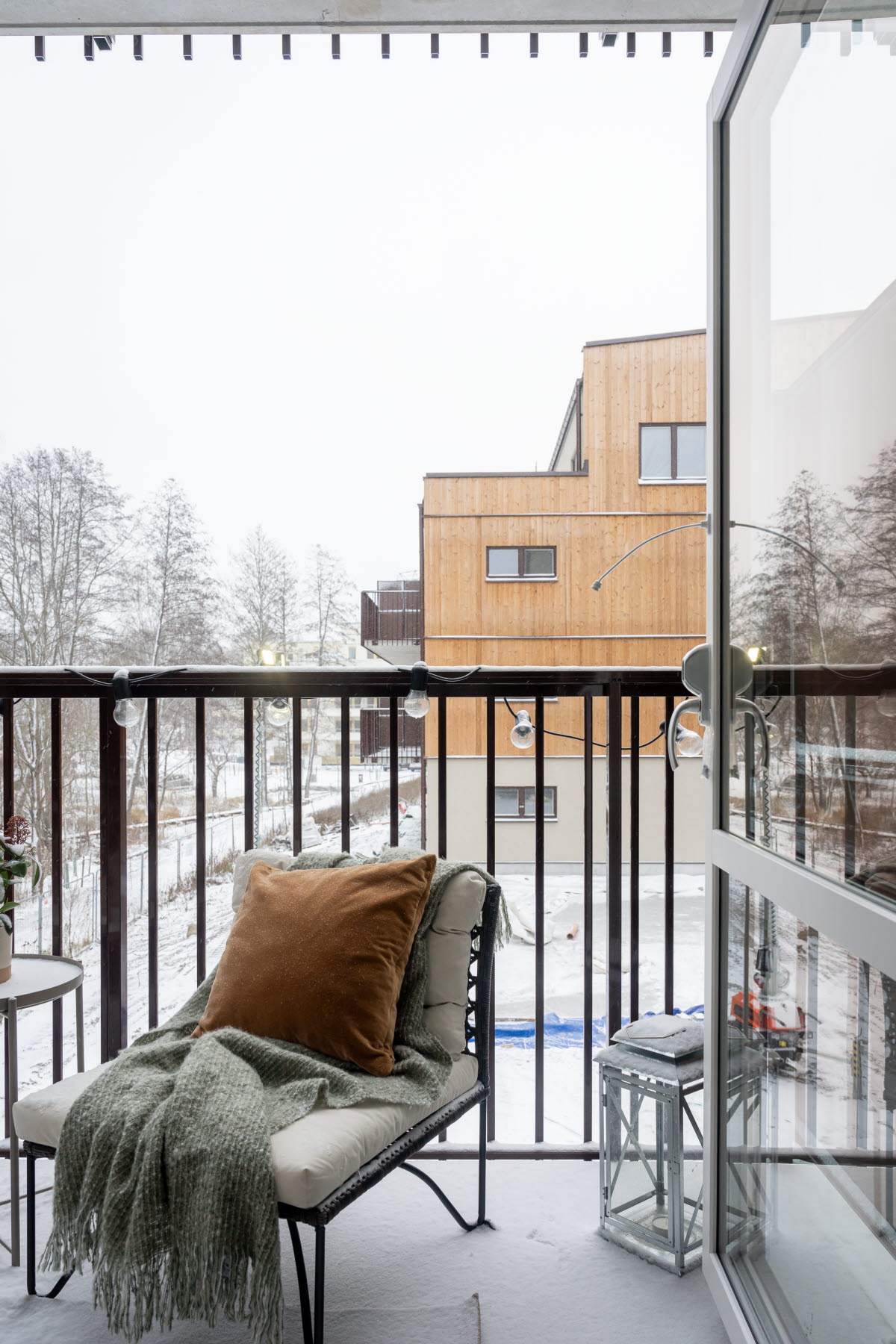 Balkong med utsikt mot grannhuset som har en träfasad.