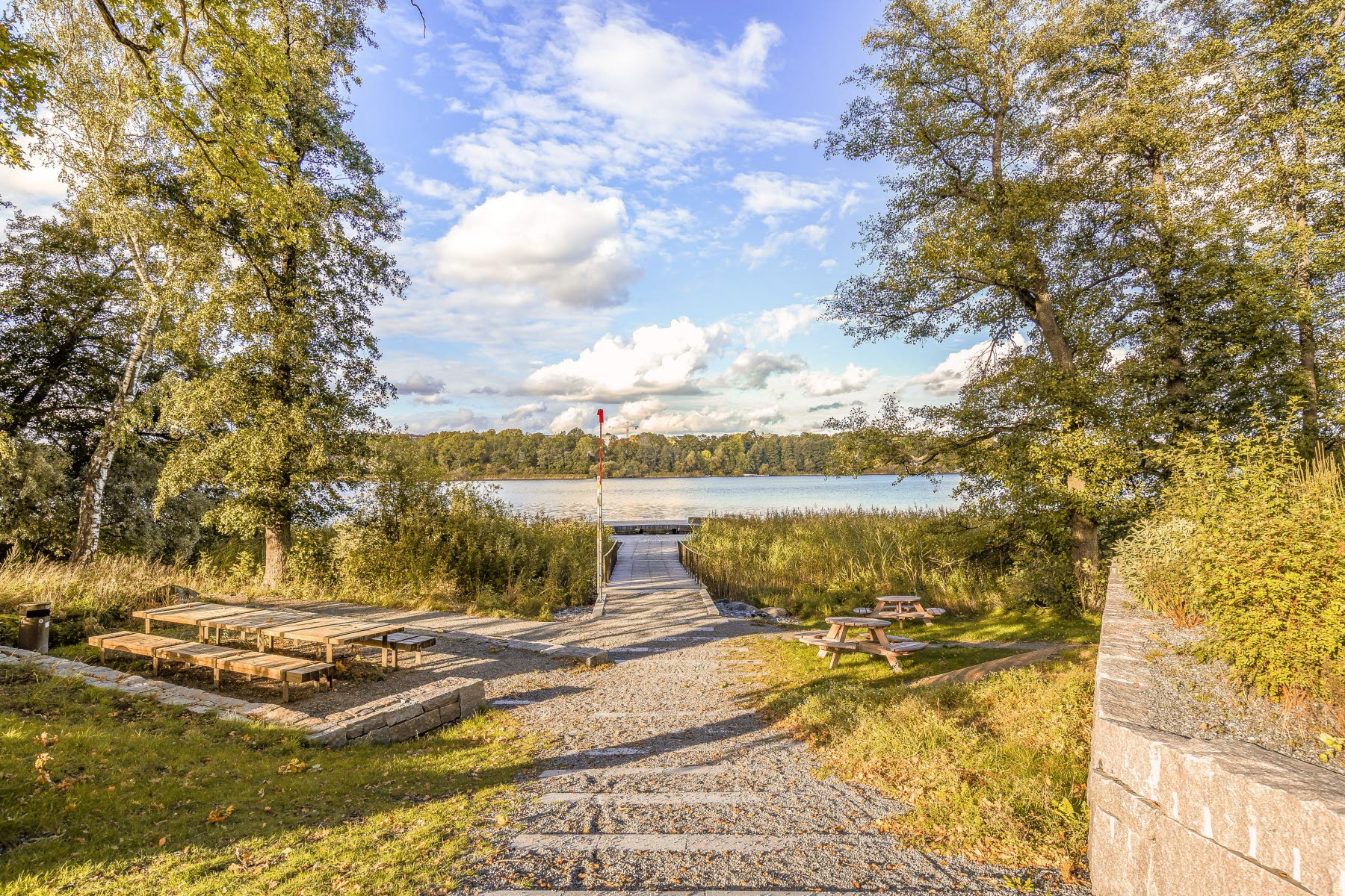 Områdesbild sensommar. Promenadstig mot brygga.