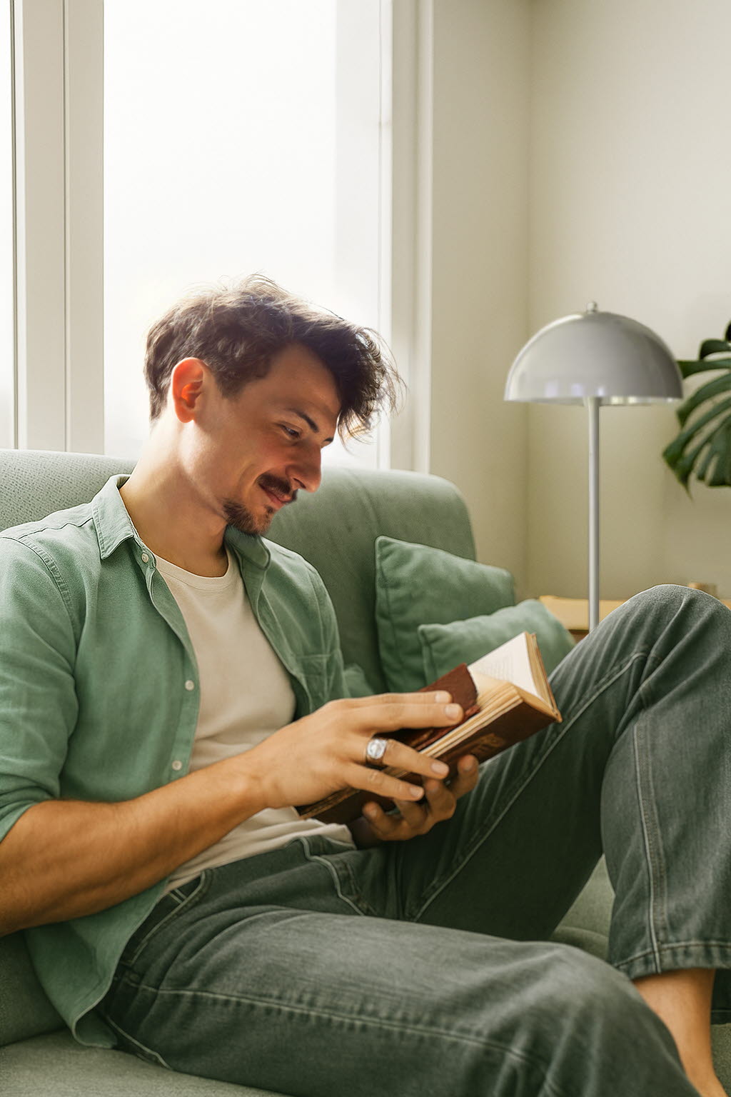 ung man i soffa som bläddrar i bok