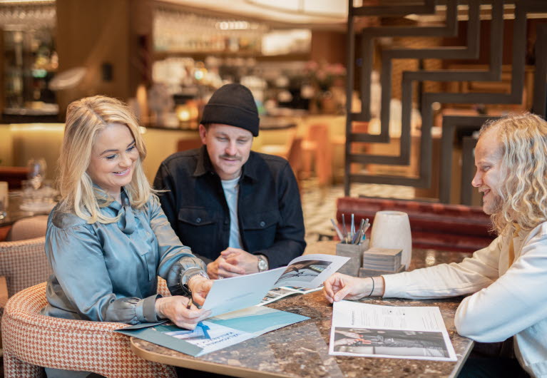 Fyra personer arbetar i ett öppet kontorslandskap.