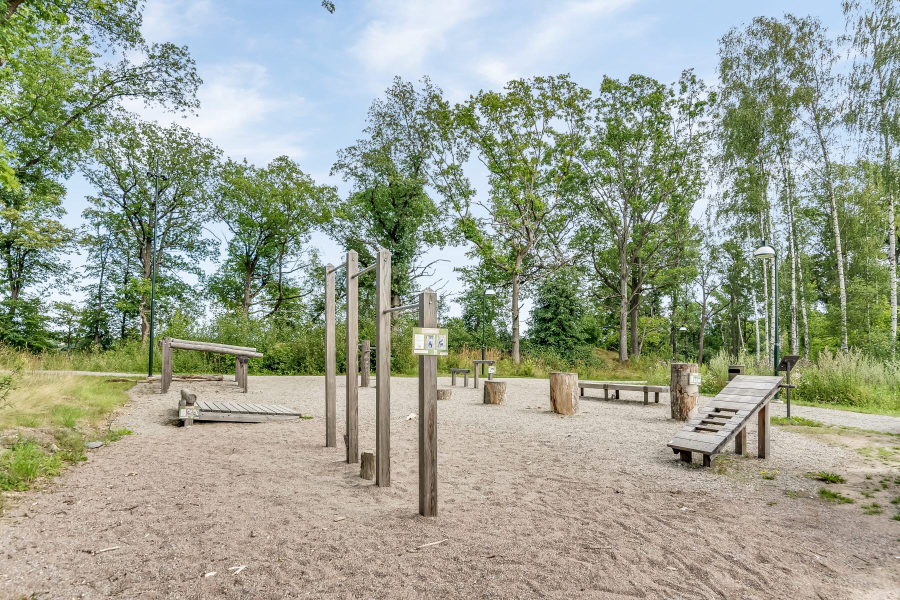 Områdesbild sommar. Utegym på grus.