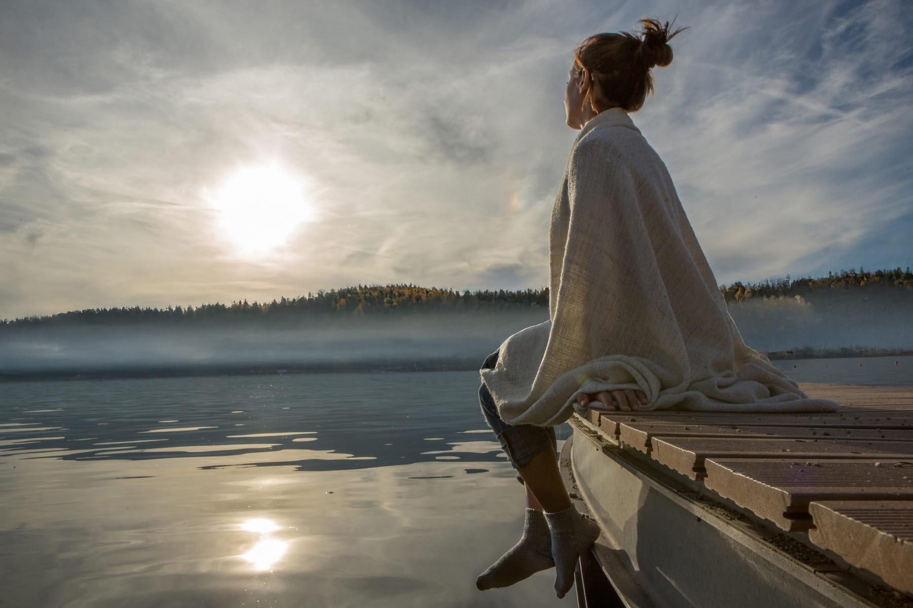 tjej vid brygga och morgonsol