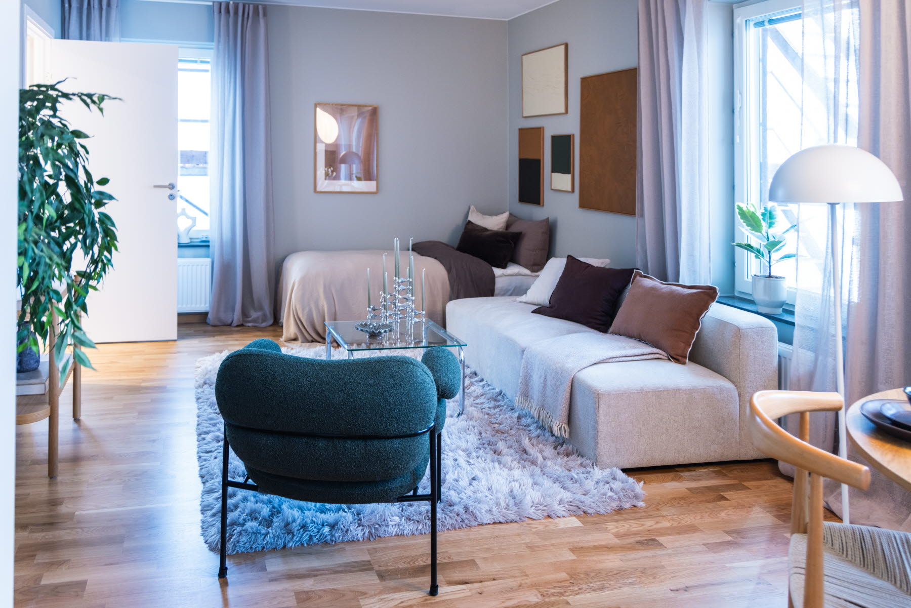 Visningslägenhet - Från kök mot fåtölj, soffa, säng och klädkammare