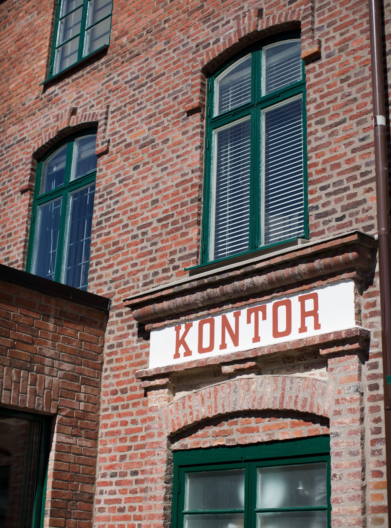 skylt på tegelfasad i bruksanda. På skylten står det kontor.